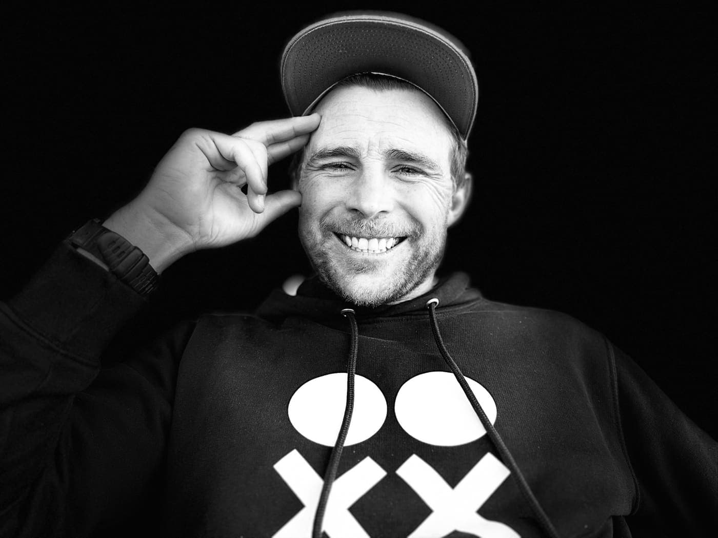 Al, smiling, in a cap and hoodie